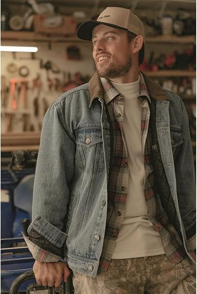 Man wearing a classic denim jacket layered over a flannel shirt